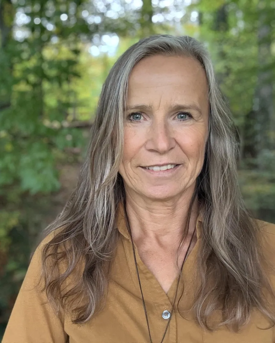 Grazyna von Lonski lächelt, im Hintergrund grüner Wald